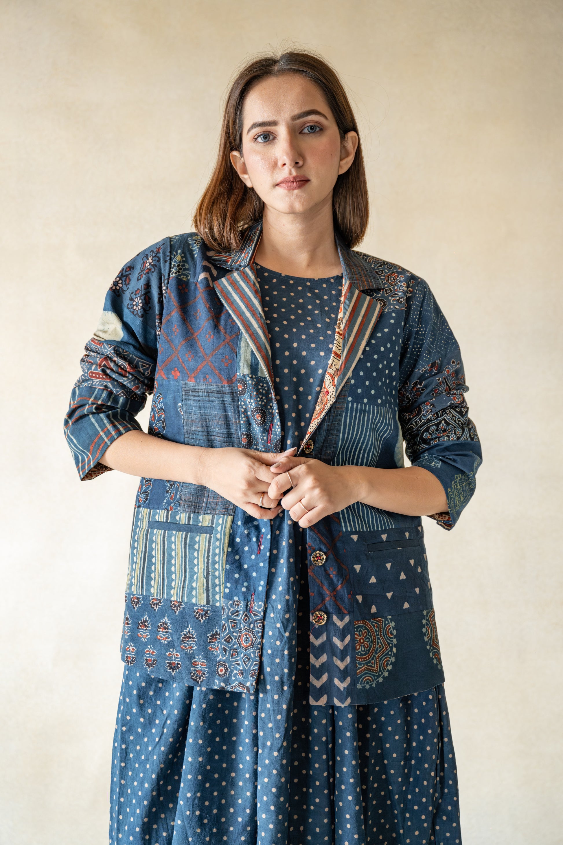 Embrace your adventurous spirit and make a statement with our Indigo Tapestry Fusion - Ajrakh Indigo Jacket, Where Heritage Meets Contemporary. Crafted with natural indigo dyed fabrics and multi-ajrakh hand block prints, this jacket is a masterpiece of slow made artistry and bohemian style. Its notch collared neck, full sleeves, and luxurious ajrakh lining create a one-of-a-kind piece that will elevate any outfit. Stand out from the crowd with this uniquely stylish jacket!