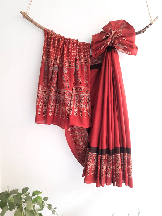 Ajrakh hand block print pure cotton saree dyed in vibrant madder hues, showcasing intricate traditional patterns.