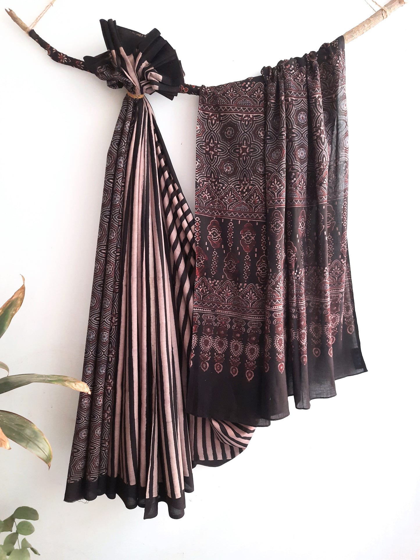 Embrace timeless elegance with our Ajrakh Black Cotton Saree. Intricately adorned with ajrakh hand block prints, this saree blends captivating stripes with classic designs. Crafted from 100% cotton, it seamlessly fuses style and comfort. Meticulously made with care, it's a stunning addition to your collection, embodying sophistication and grace.