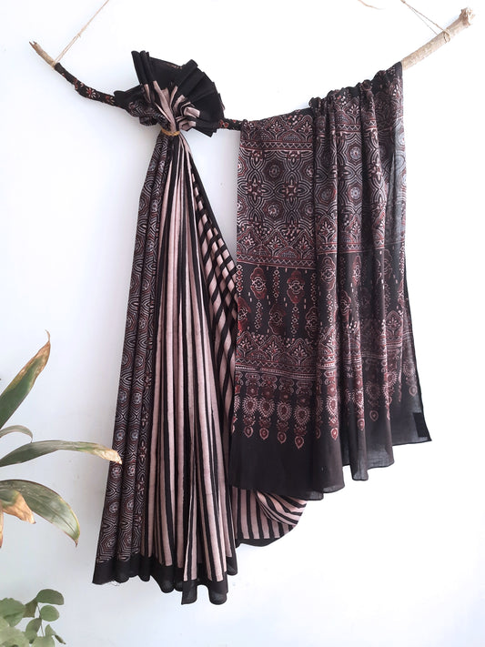 Embrace timeless elegance with our Ajrakh Black Cotton Saree. Intricately adorned with ajrakh hand block prints, this saree blends captivating stripes with classic designs. Crafted from 100% cotton, it seamlessly fuses style and comfort. Meticulously made with care, it's a stunning addition to your collection, embodying sophistication and grace.