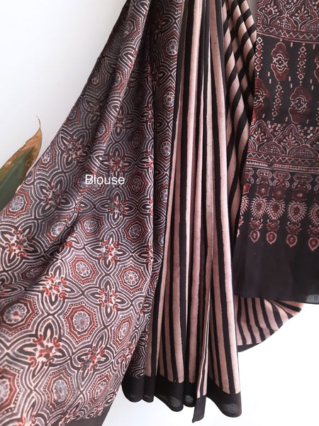 Embrace timeless elegance with our Ajrakh Black Cotton Saree. Intricately adorned with ajrakh hand block prints, this saree blends captivating stripes with classic designs. Crafted from 100% cotton, it seamlessly fuses style and comfort. Meticulously made with care, it's a stunning addition to your collection, embodying sophistication and grace.