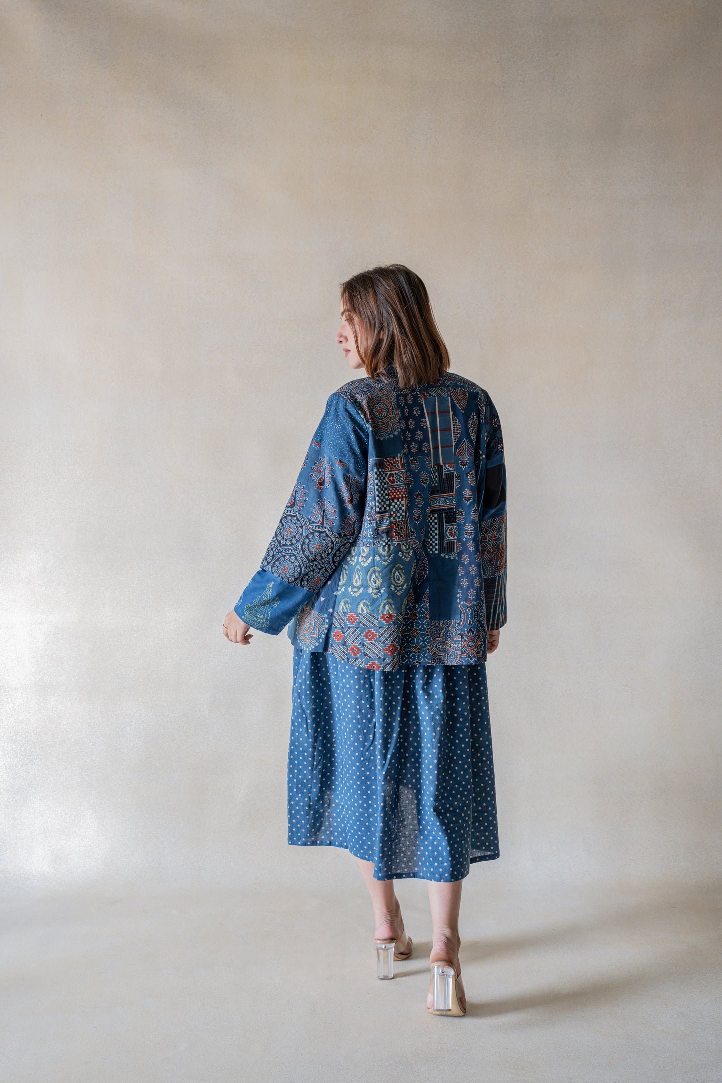 Embrace your adventurous spirit and make a statement with our Indigo Tapestry Fusion - Ajrakh Indigo Jacket, Where Heritage Meets Contemporary. Crafted with natural indigo dyed fabrics and multi-ajrakh hand block prints, this jacket is a masterpiece of slow made artistry and bohemian style. Its notch collared neck, full sleeves, and luxurious ajrakh lining create a one-of-a-kind piece that will elevate any outfit. Stand out from the crowd with this uniquely stylish jacket!