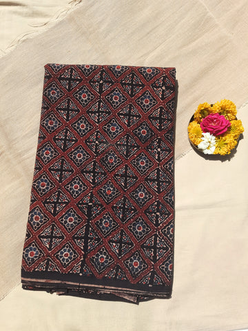 Black Ajrakh hand block printed fabric, handcrafted by skilled artisans of Gujarat. Made from 100% pure cotton and dyed using natural plant-based dyes, this eco-friendly fabric features intricate traditional patterns. Soft, breathable, and comfortable, with a width of 44 inches, it is perfect for sarees, kurtas, dresses, dupattas, and home decor. A timeless piece of Indian textile heritage, consciously crafted using sustainable and ethical practices.