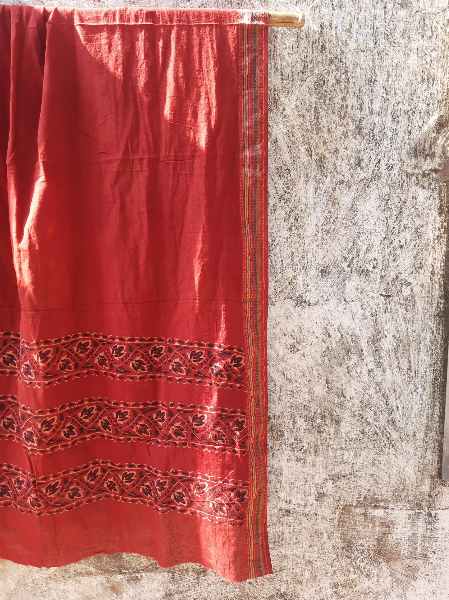 Madder-dyed pure cotton dupatta featuring intricate Ajrakh hand block printed borders. Crafted mindfully and naturally dyed, this lightweight and breathable dupatta adds a touch of Indian tradition to any outfit. Perfect for festive or everyday wear.