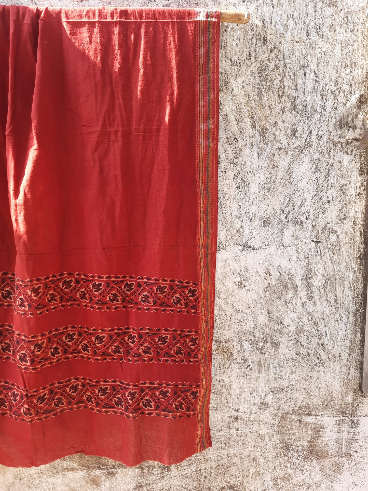 Madder-dyed pure cotton dupatta featuring intricate Ajrakh hand block printed borders. Crafted mindfully and naturally dyed, this lightweight and breathable dupatta adds a touch of Indian tradition to any outfit. Perfect for festive or everyday wear.