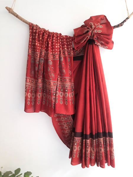 Ajrakh hand block print pure cotton saree dyed in vibrant madder hues, showcasing intricate traditional patterns.