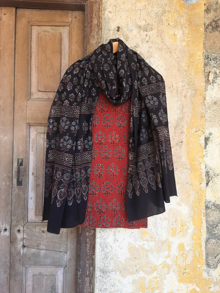 Handcrafted Ajrakh suit set in pure cotton, featuring intricate hand block prints and natural madder dye. Paired with a black dupatta, slow-made, breathable, and eco-friendly.