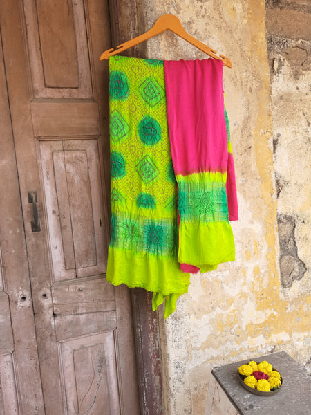 Handcrafted green and pink Rai Dani Bandhani 3-piece suit set in Gajji silk. Includes unstitched top, bottom, and dupatta with subtle zari borders. Traditional Indian wear.