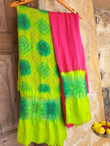 Handcrafted green and pink Rai Dani Bandhani 3-piece suit set in Gajji silk. Includes unstitched top, bottom, and dupatta with subtle zari borders. Traditional Indian wear.