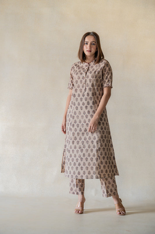 Exquisitely handcrafted with sourced materials, the Vrinda Co-ord Set is designed to bring effortless sophistication into your wardrobe. The ajrakh boota print kurta and pants set, dyed with natural resources, feature a mandarin collared neck, frills on the sleeves hem, and front pockets for extra convenience. The pants come with an elasticated waistband for a comfortable fit. This slow-made ensemble is perfect for everyday wear.