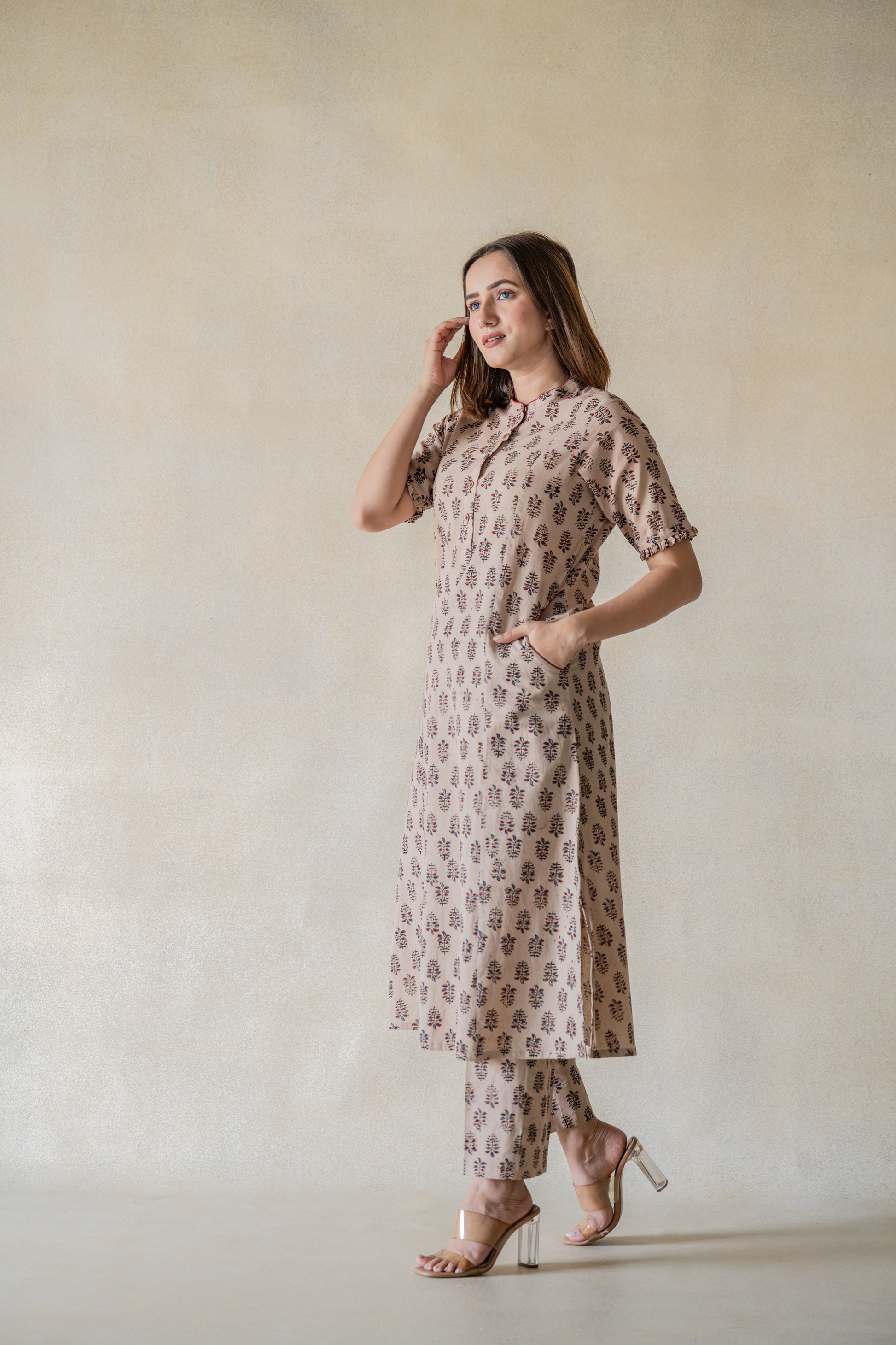 Exquisitely handcrafted with sourced materials, the Vrinda Co-ord Set is designed to bring effortless sophistication into your wardrobe. The ajrakh boota print kurta and pants set, dyed with natural resources, feature a mandarin collared neck, frills on the sleeves hem, and front pockets for extra convenience. The pants come with an elasticated waistband for a comfortable fit. This slow-made ensemble is perfect for everyday wear.