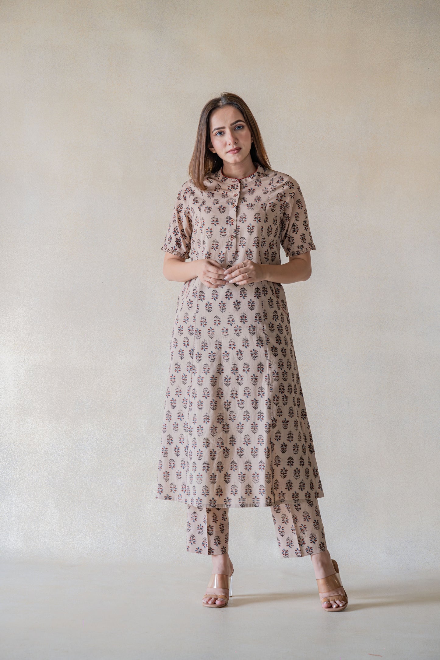 Exquisitely handcrafted with sourced materials, the Vrinda Co-ord Set is designed to bring effortless sophistication into your wardrobe. The ajrakh boota print kurta and pants set, dyed with natural resources, feature a mandarin collared neck, frills on the sleeves hem, and front pockets for extra convenience. The pants come with an elasticated waistband for a comfortable fit. This slow-made ensemble is perfect for everyday wear.