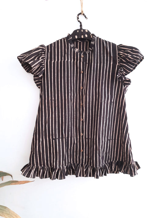 "Alt text: Monochrome elegance in our Rhythm in Monochrome black striped shirt for her. Handcrafted with ajrakh printing, sustainable and naturally dyed. Unique ruffles on sleeves, hem, and collar for the perfect blend of comfort and chicness. Elevate your wardrobe with this statement piece."