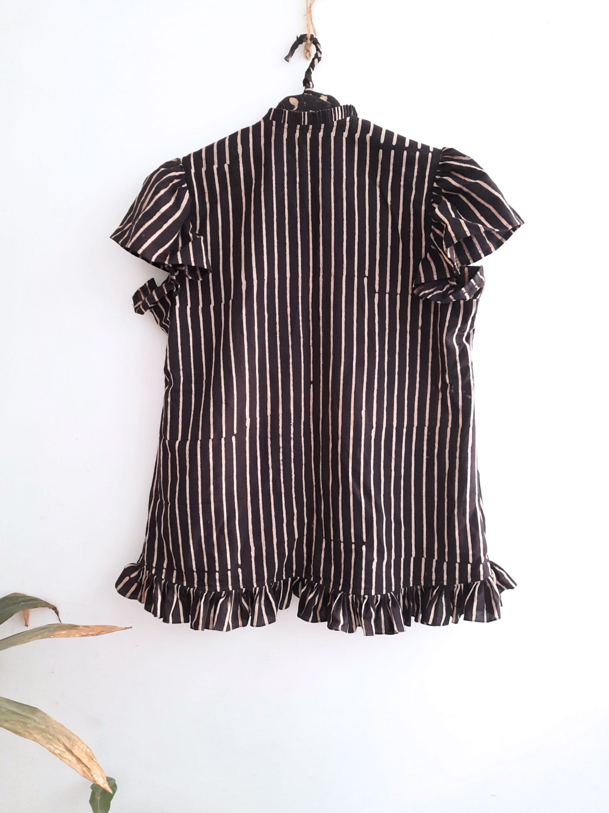 Monochrome elegance in our Rhythm in Monochrome black striped shirt for her. Handcrafted with ajrakh printing, sustainable and naturally dyed. Unique ruffles on sleeves, hem, and collar for the perfect blend of comfort and chicness. Elevate your wardrobe with this statement piece.