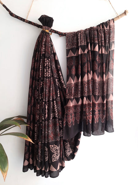 Charcoal Black Ajrakh Saree, combining artisanal expertise with natural dyes and hand block printing. Made from pure cotton, it offers both style and comfort. Slow made and conscious, it's a tasteful addition to your collection. Includes a running blouse for a complete, luxurious look.