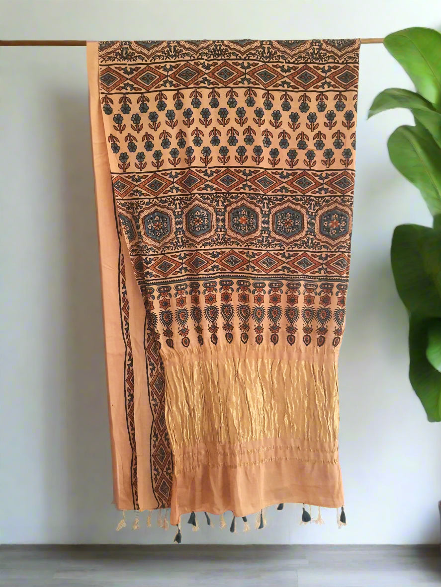 Earthy peach modal silk saree dyed using seasonal flowers with eco prints on the body and traditional Ajrakh designs on the pallu. Handcrafted, natural dyed, sustainable fashion, includes a blouse piece. Saree length: 6.65 meters, width: 44 inches.