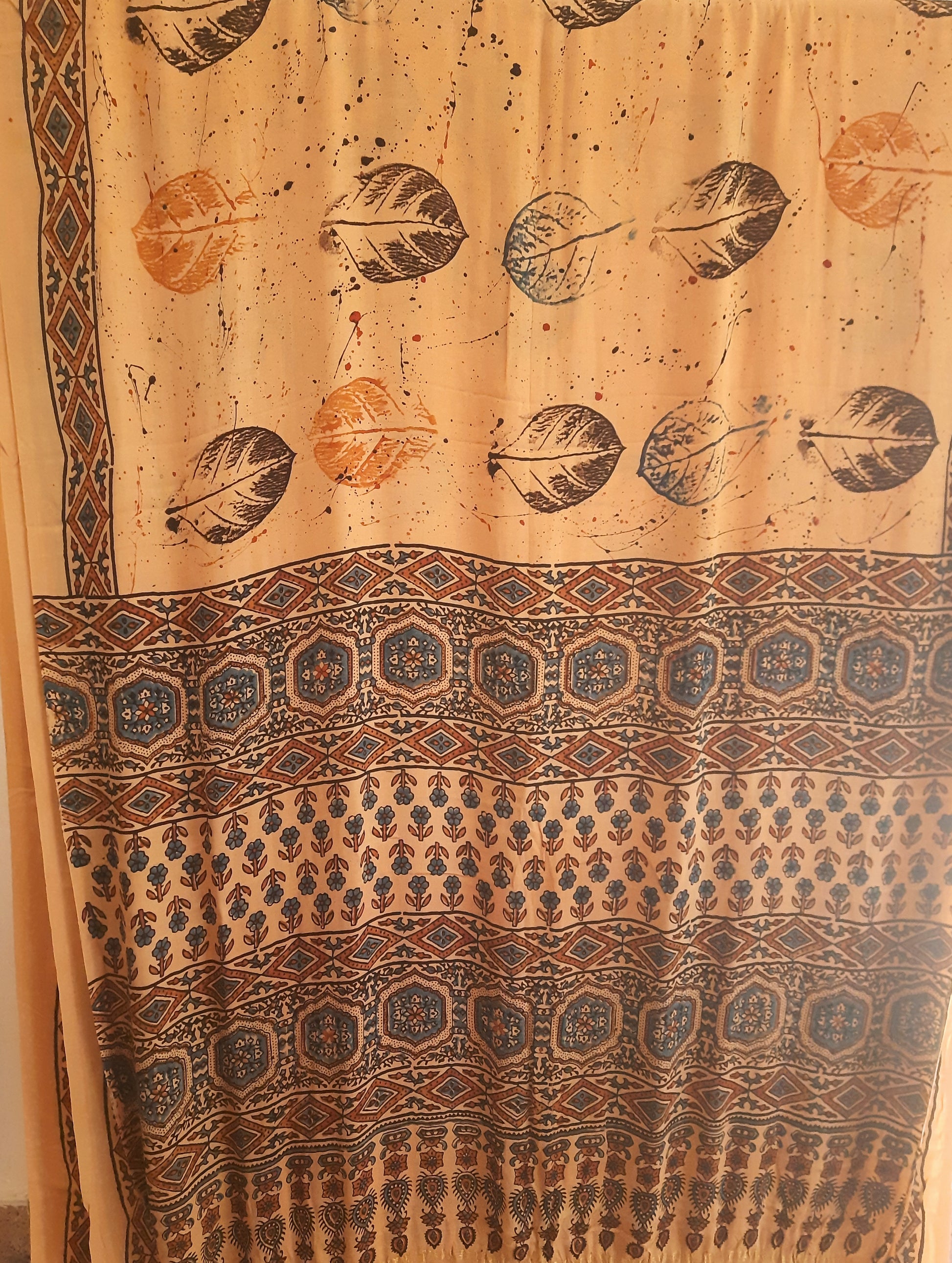 Earthy peach modal silk saree dyed using seasonal flowers with eco prints on the body and traditional Ajrakh designs on the pallu. Handcrafted, natural dyed, sustainable fashion, includes a blouse piece. Saree length: 6.65 meters, width: 44 inches.