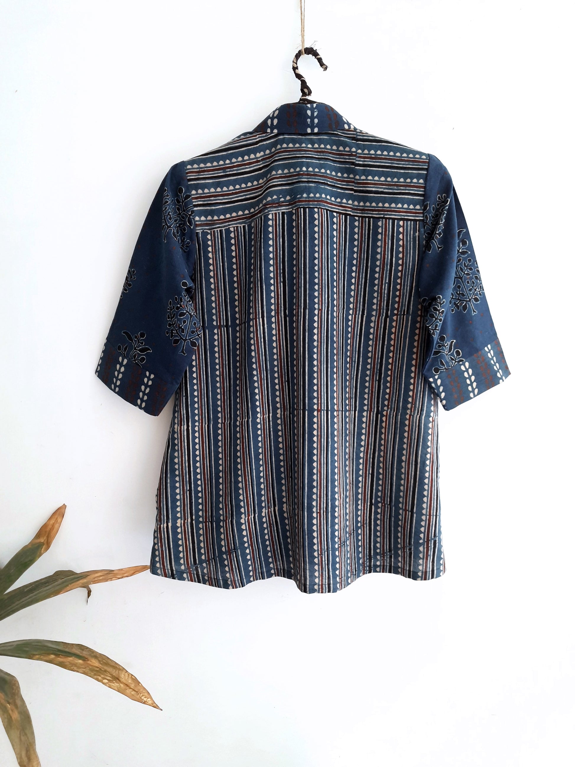 Image: Breezy Indigo Ajrakh Fusion shirt for women, featuring hand block prints in polkas, bootas, and stripes. Crafted with care, this indigo dyed shirt adds artisanal charm to any wardrobe. Shop now at Turquoisethestore.