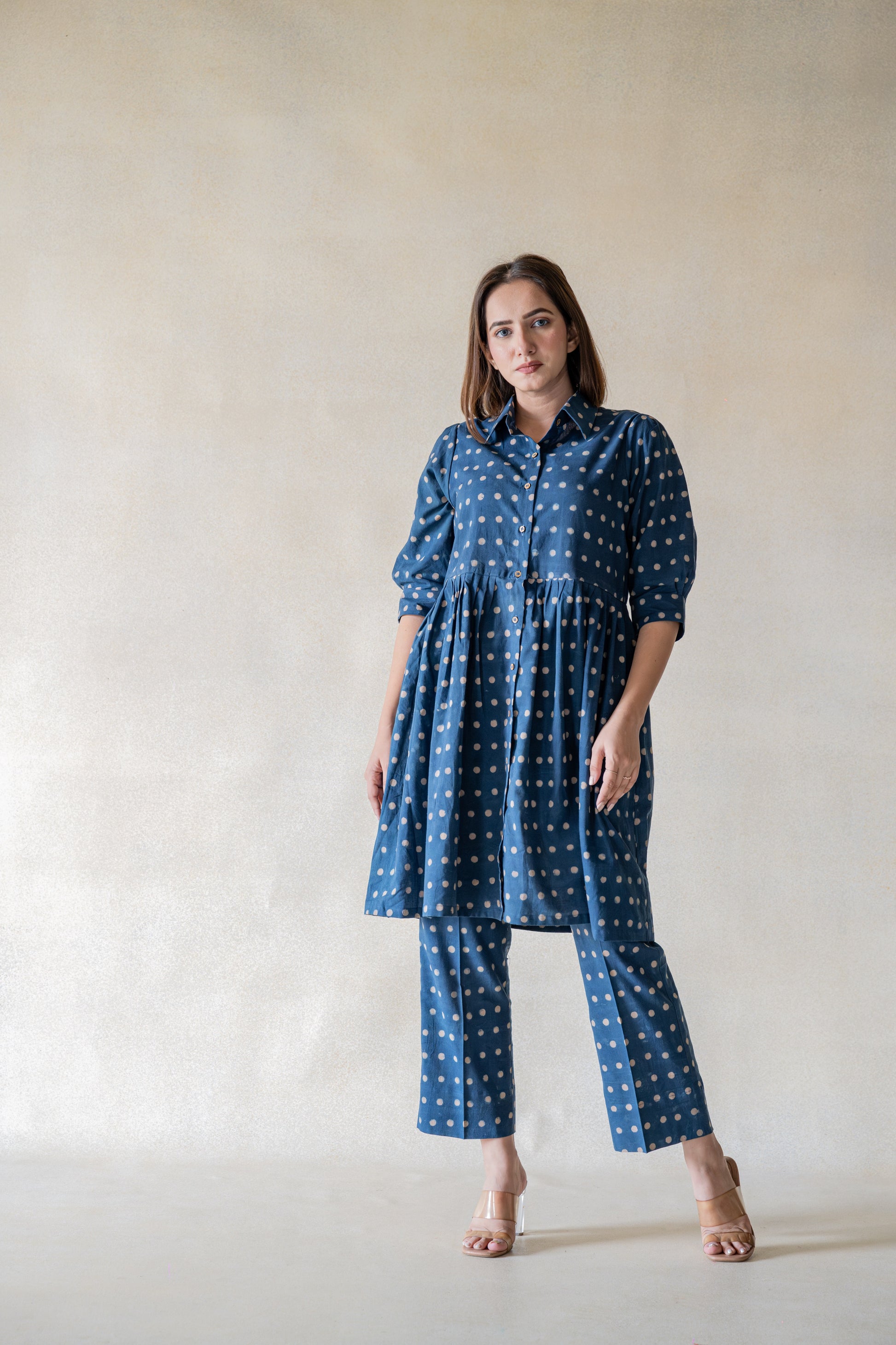 Get ready to make a statement with our Starry Indigo Daydream coord set! The ajrakh hand block printed polka dots add a unique touch to this chic and classy ensemble. The subtle waist gather on the flowy shirt and elasticated waist pants make this the perfect comfortable yet stylish choice for modern women.
