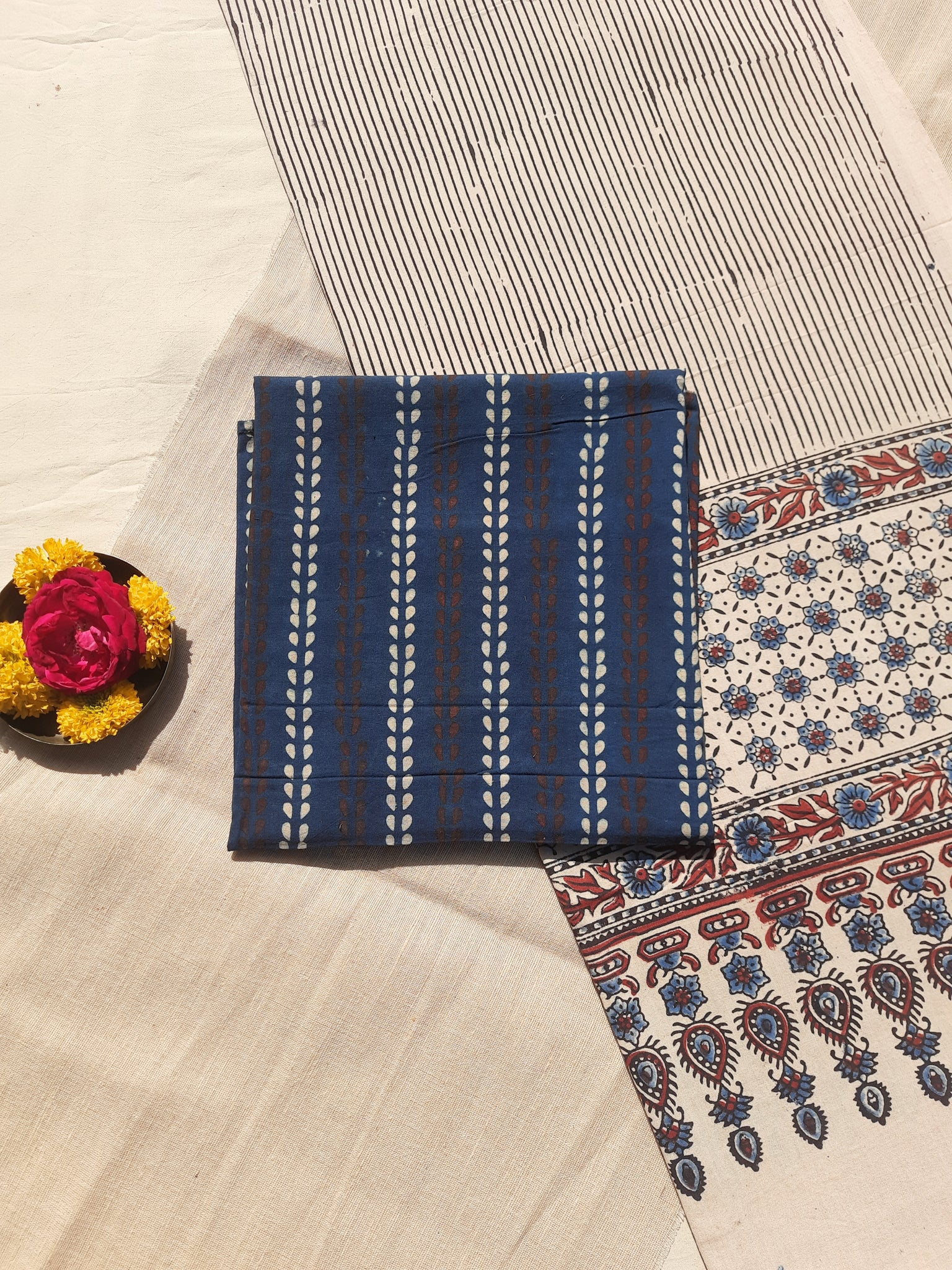 Ajrakh hand block printed two-piece suit set in pure cotton, featuring an indigo booti print top and a Myrobalan-dyed dupatta with traditional motifs. Naturally dyed, eco-friendly, and handcrafted by artisans for a timeless ethnic look.