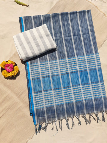 Handwoven shades of blue cotton saree, lightweight and breathable. Ethically crafted with a soft drape, paired with a hand-spun organic cotton blouse piece in off-white and grey stripes. Perfect for effortless elegance and everyday comfort.