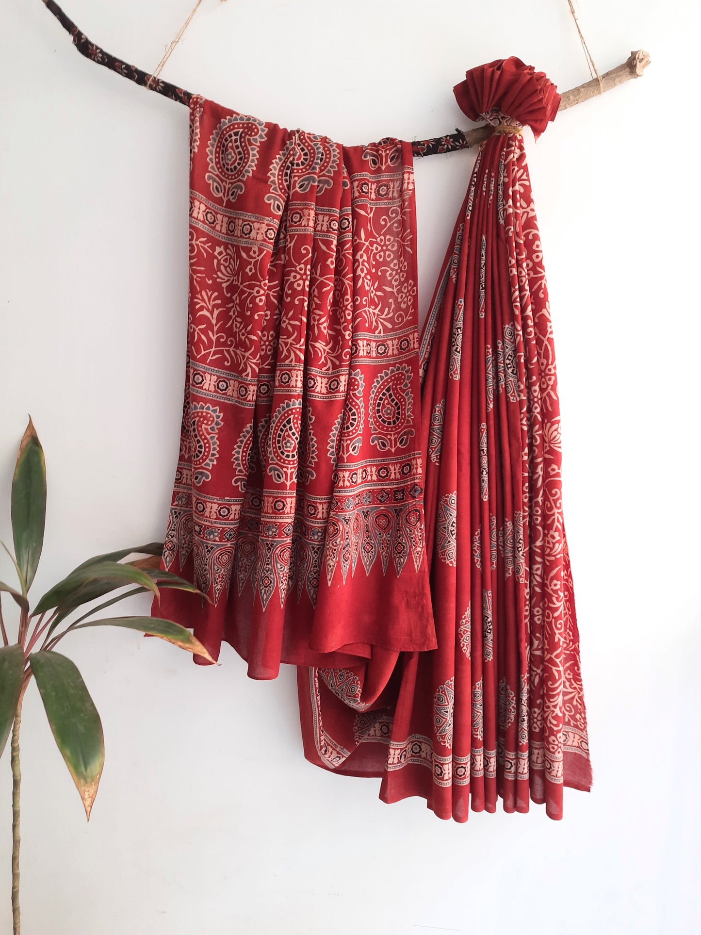Experience the beauty of slow fashion with our Madder Red Ajrakh Cotton Saree. Carefully crafted by skilled artisans, this saree features a stunning madder dye and intricate ajrakh hand block printing. Made with pure cotton, it comes with a running blouse for convenience. Create a sustainable and stylish wardrobe with this unique piece