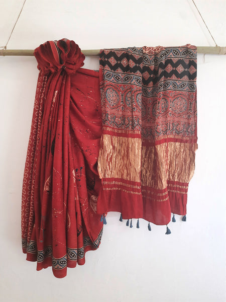 Madder-dyed Ajrakh hand block printed saree in soft and luxurious modal silk. Features eco-prints on the body, Ajrakh prints on the pallu and blouse. Naturally dyed and handcrafted by Indian artisans in Gujarat. Perfect for traditional saree lovers.