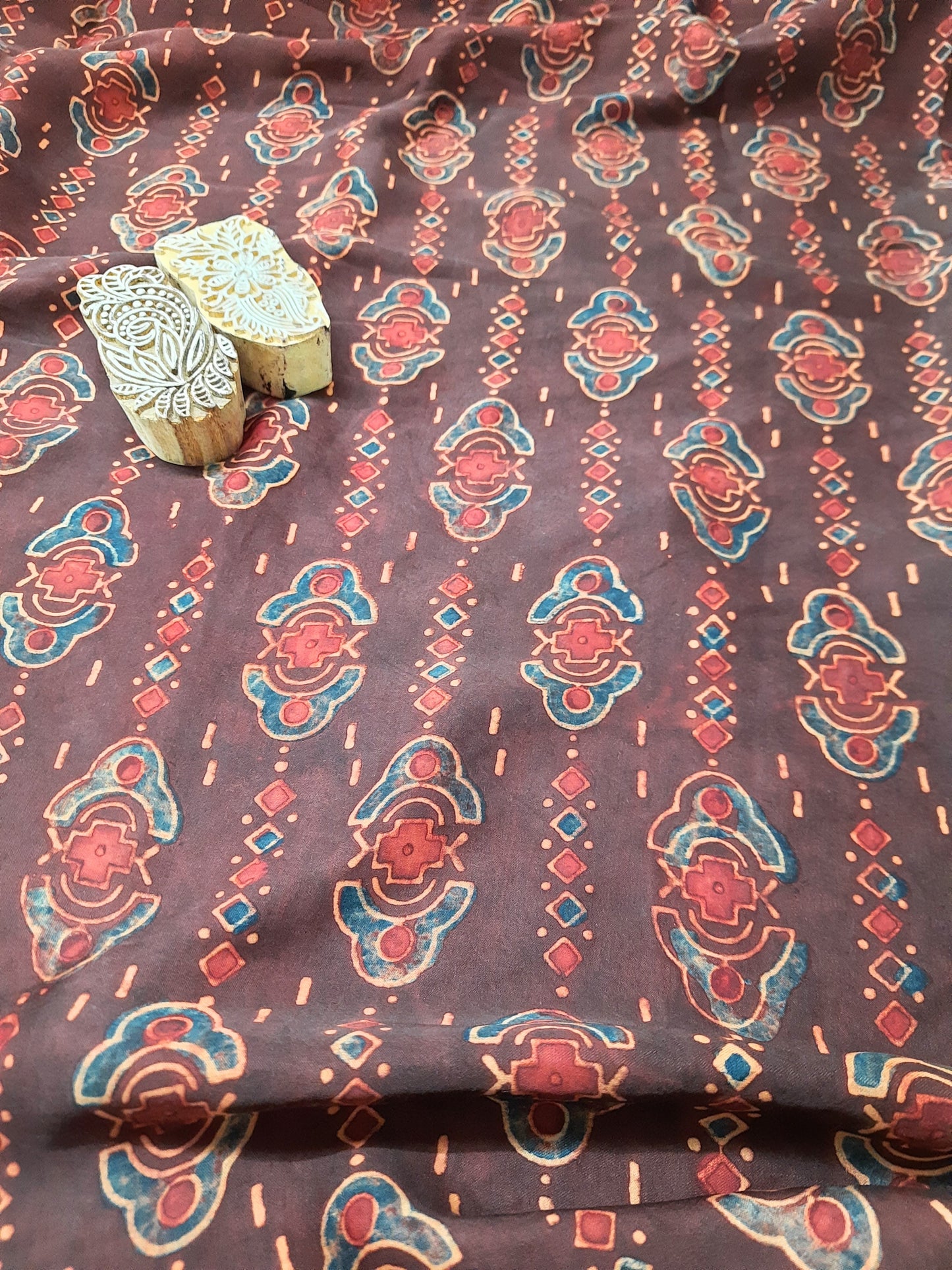 Transform your wardrobe with our luxurious Modal Silk - Rusty Maroon Ajrakh Hand Block Print Fabric. Experience the softness and flow of modal silk while embracing the beauty of artisan handmade ajrakh block prints. Elevate your style with this sustainable, exclusive fabric.