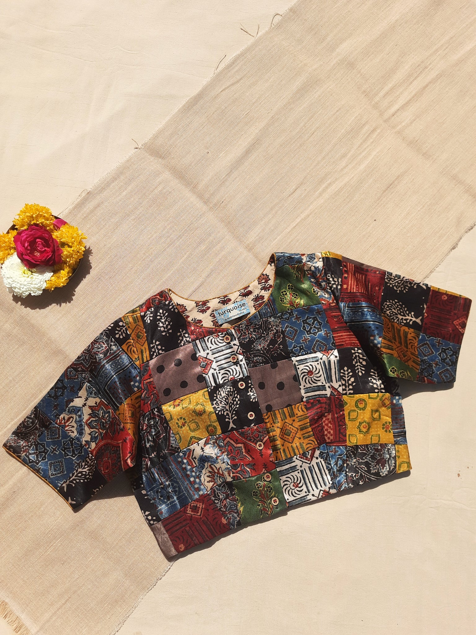 Handcrafted upcycled Mashru silk blouse featuring Ajrakh patchwork prints, naturally dyed, and lined with pure cotton. Boho-chic, vintage-inspired design with a front button closure, round neckline, and perfect finishing. Ethnic, slow-made, and eco-conscious.