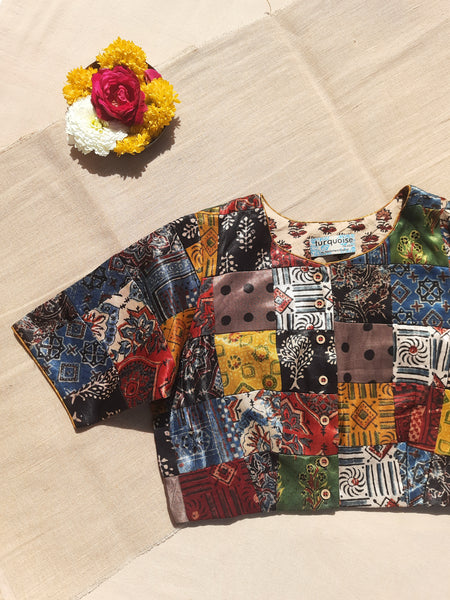 Handcrafted upcycled Mashru silk blouse featuring Ajrakh patchwork prints, naturally dyed, and lined with pure cotton. Boho-chic, vintage-inspired design with a front button closure, round neckline, and perfect finishing. Ethnic, slow-made, and eco-conscious.