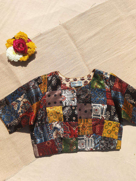 Handcrafted upcycled Mashru silk blouse featuring Ajrakh patchwork prints, naturally dyed, and lined with pure cotton. Boho-chic, vintage-inspired design with a front button closure, round neckline, and perfect finishing. Ethnic, slow-made, and eco-conscious.