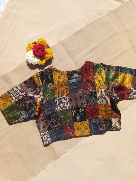 Handcrafted upcycled Mashru silk blouse featuring Ajrakh patchwork prints, naturally dyed, and lined with pure cotton. Boho-chic, vintage-inspired design with a front button closure, round neckline, and perfect finishing. Ethnic, slow-made, and eco-conscious.