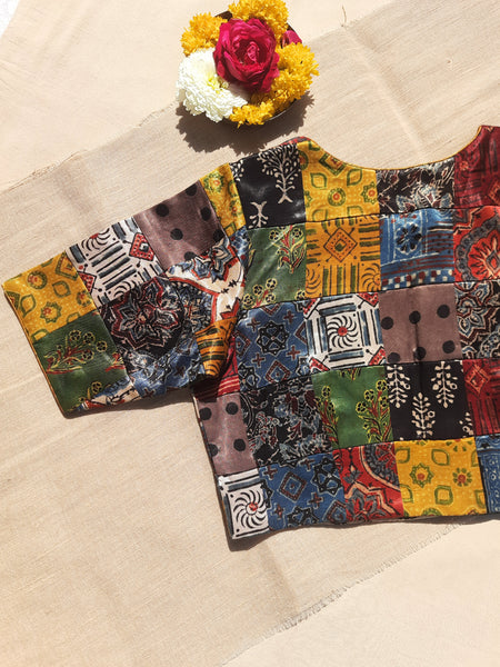 Handcrafted upcycled Mashru silk blouse featuring Ajrakh patchwork prints, naturally dyed, and lined with pure cotton. Boho-chic, vintage-inspired design with a front button closure, round neckline, and perfect finishing. Ethnic, slow-made, and eco-conscious.