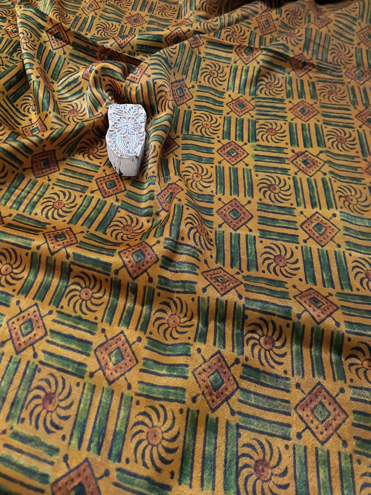 Indulge in the luxurious feel of Mashru silk fabric, hand block printed with the intricate ajrakh design. The unique turmeric dye makes this fabric even more special, while supporting eco-friendly fashion. Elevate your wardrobe with this artisan-crafted  fabric.