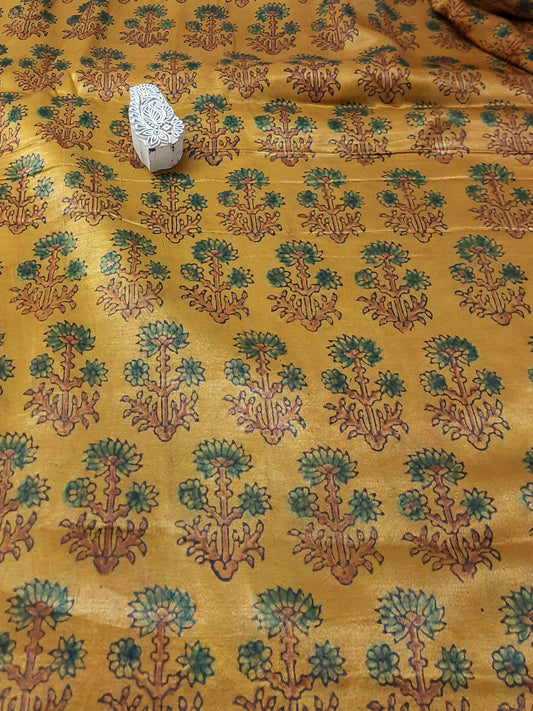 Experience the opulent touch of Mashru silk fabric, adorned with the exquisite ajrakh design. The one-of-a-kind turmeric dye adds to the fabric's charm and promotes sustainable fashion. Create your own stunning design with our eco-friendly, luxurious fabric for an elegant aesthetic.