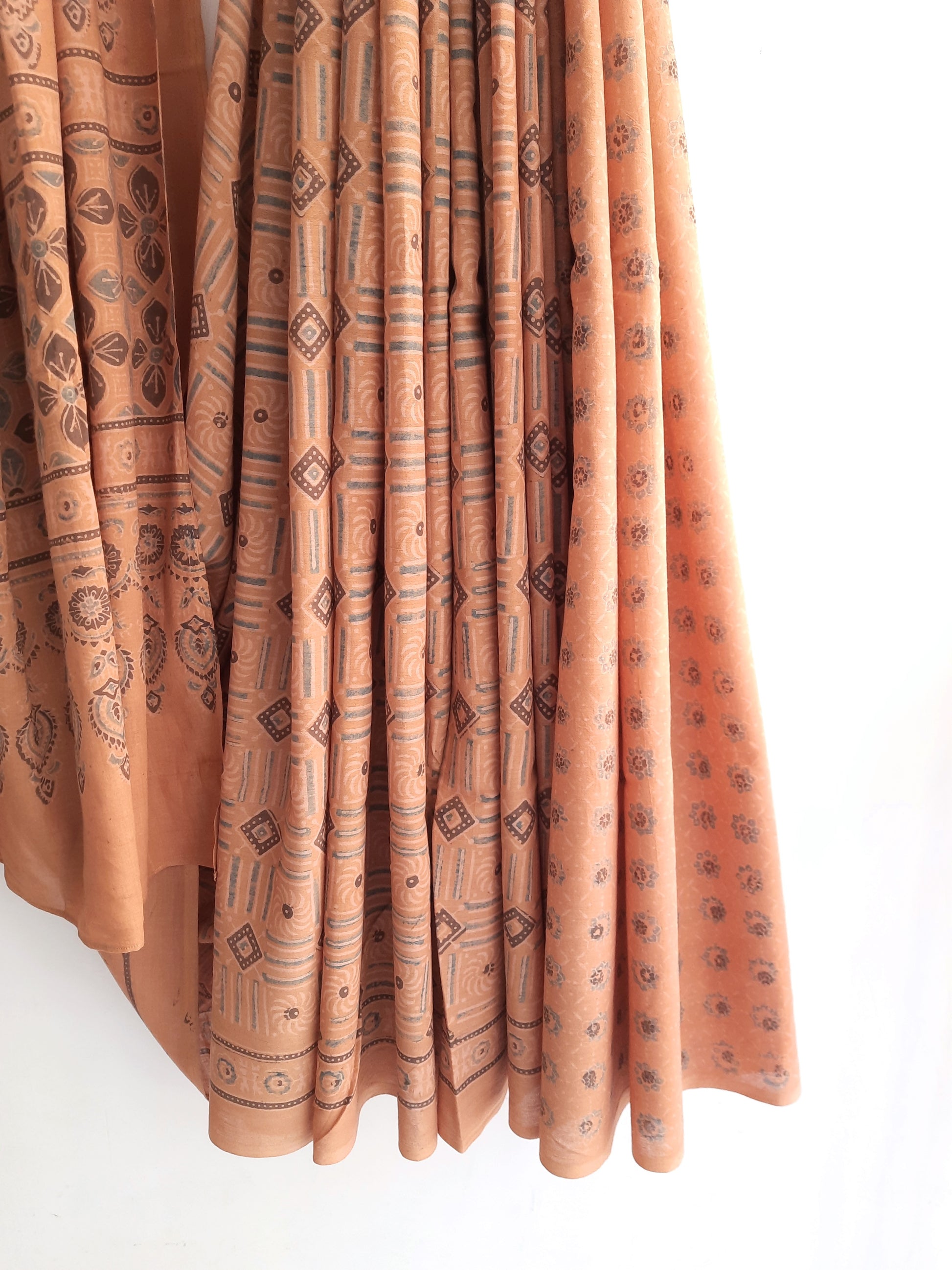 Embrace grace with our Earthy Peach Ajrakh Saree, meticulously crafted in pure cotton. Dyed using seasonal flowers, it exudes subtle elegance, a harmonious blend of nature and tradition.