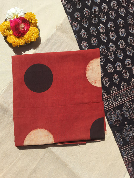 Image of the handcrafted Ajrakh Cosmic Polka Dots Suit Set, featuring cosmic polka dots hand block printed on madder-dyed pure cotton. The set includes a stunning black Ajrakh dupatta with floral and paisley motifs, all naturally dyed and eco-friendly.