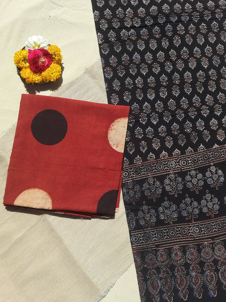 Image of the handcrafted Ajrakh Cosmic Polka Dots Suit Set, featuring cosmic polka dots hand block printed on madder-dyed pure cotton. The set includes a stunning black Ajrakh dupatta with floral and paisley motifs, all naturally dyed and eco-friendly.