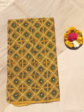 Turmeric yellow Ajrakh hand block printed pure cotton fabric, 44" wide. Naturally dyed, eco-friendly, breathable, and handmade by Indian artisans. Perfect for sarees, dress materials, and dupattas. Crafted using traditional techniques for sustainable fashion.