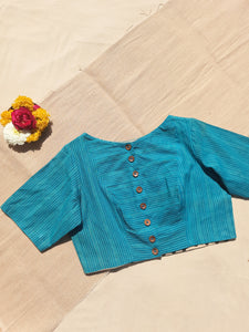 Turquoise blue handmade blouse crafted from pure cotton with self-embroidery, natural dyed polka dots lining, wooden button fastening, and boat neck design.