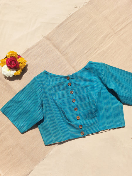 Turquoise blue handmade blouse crafted from pure cotton with self-embroidery, natural dyed polka dots lining, wooden button fastening, and boat neck design.