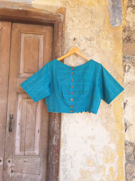 Turquoise blue handmade blouse crafted from pure cotton with self-embroidery, natural dyed polka dots lining, wooden button fastening, and boat neck design.