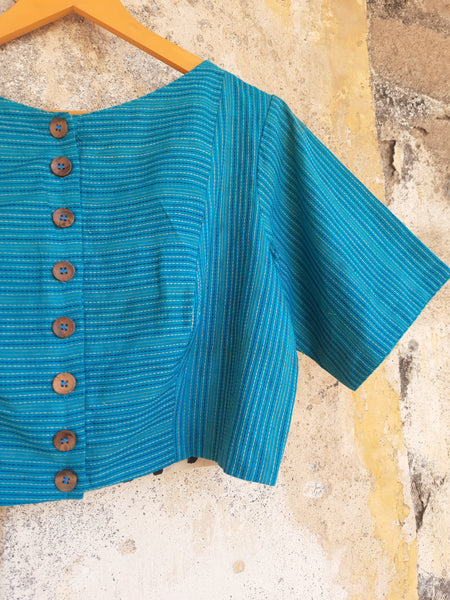 Turquoise blue handmade blouse crafted from pure cotton with self-embroidery, natural dyed polka dots lining, wooden button fastening, and boat neck design.