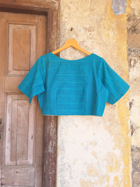 Turquoise blue handmade blouse crafted from pure cotton with self-embroidery, natural dyed polka dots lining, wooden button fastening, and boat neck design.