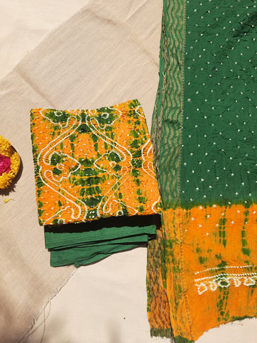 Handcrafted Shibori & Rai Dani Bandhani cotton suit set in yellow and green. Traditional Indian tie-dye dress material, artisan-made in Gujarat. Unstitched three-piece suit set, crafted consciously from pure cotton. Perfect for custom ethnic wear, salwar suits, or fusion outfits. A unique blend of heritage craftsmanship and sustainable fashion, showcasing intricate patterns and vibrant colors.