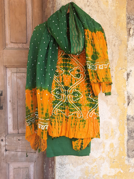 Handcrafted Shibori & Rai Dani Bandhani cotton suit set in yellow and green. Traditional Indian tie-dye dress material, artisan-made in Gujarat. Unstitched three-piece suit set, crafted consciously from pure cotton. Perfect for custom ethnic wear, salwar suits, or fusion outfits. A unique blend of heritage craftsmanship and sustainable fashion, showcasing intricate patterns and vibrant colors.